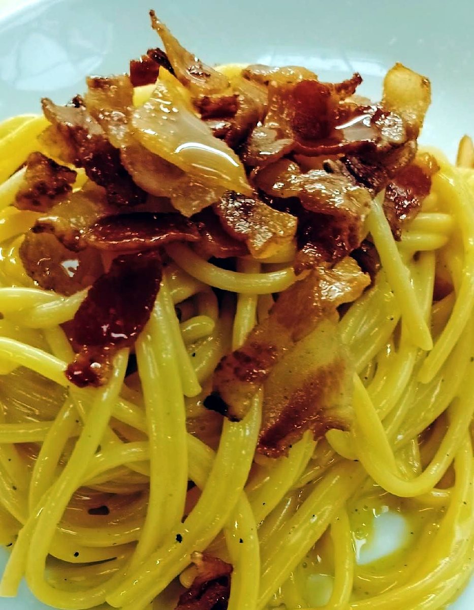 Piatto di spaghetti alla carbonara con guanciale croccante