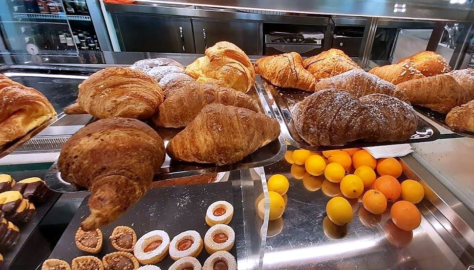 Cornetti, dolcetti e arance nella vetrina del banco