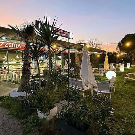 Il giardino di Koko's al tramonto con luci e ombrelloni