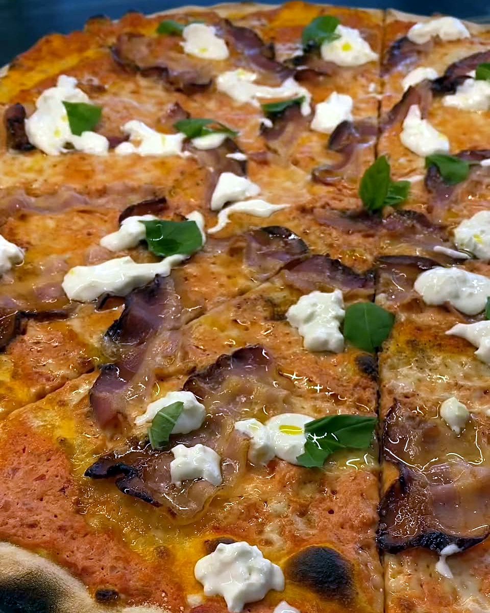 Pizza rossa con pancetta, burrata e basilico