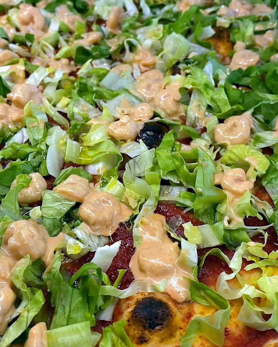 Pizza con insalata croccante e salsa rosa