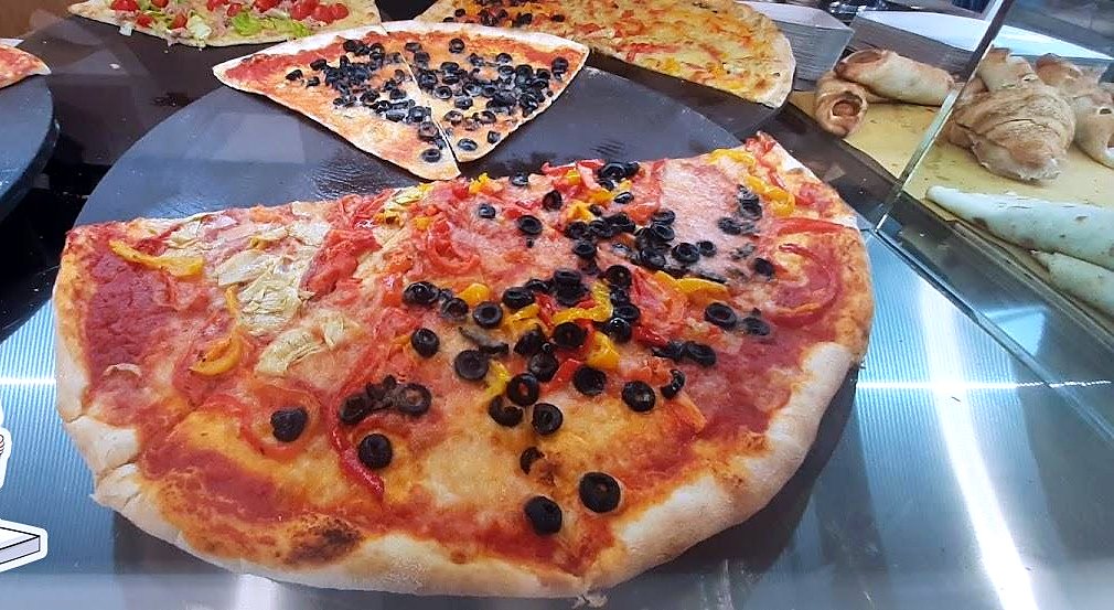Pizza al taglio nel banco: pomodoro, olive e peperoni